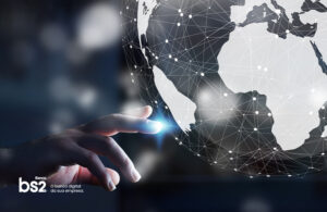 mão apontando para o Brasil em um globo terrestre digital, mostrando o mundo conectado.